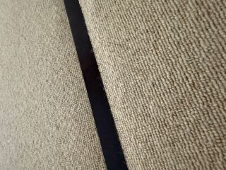matt black door bar on a cream loop carpet